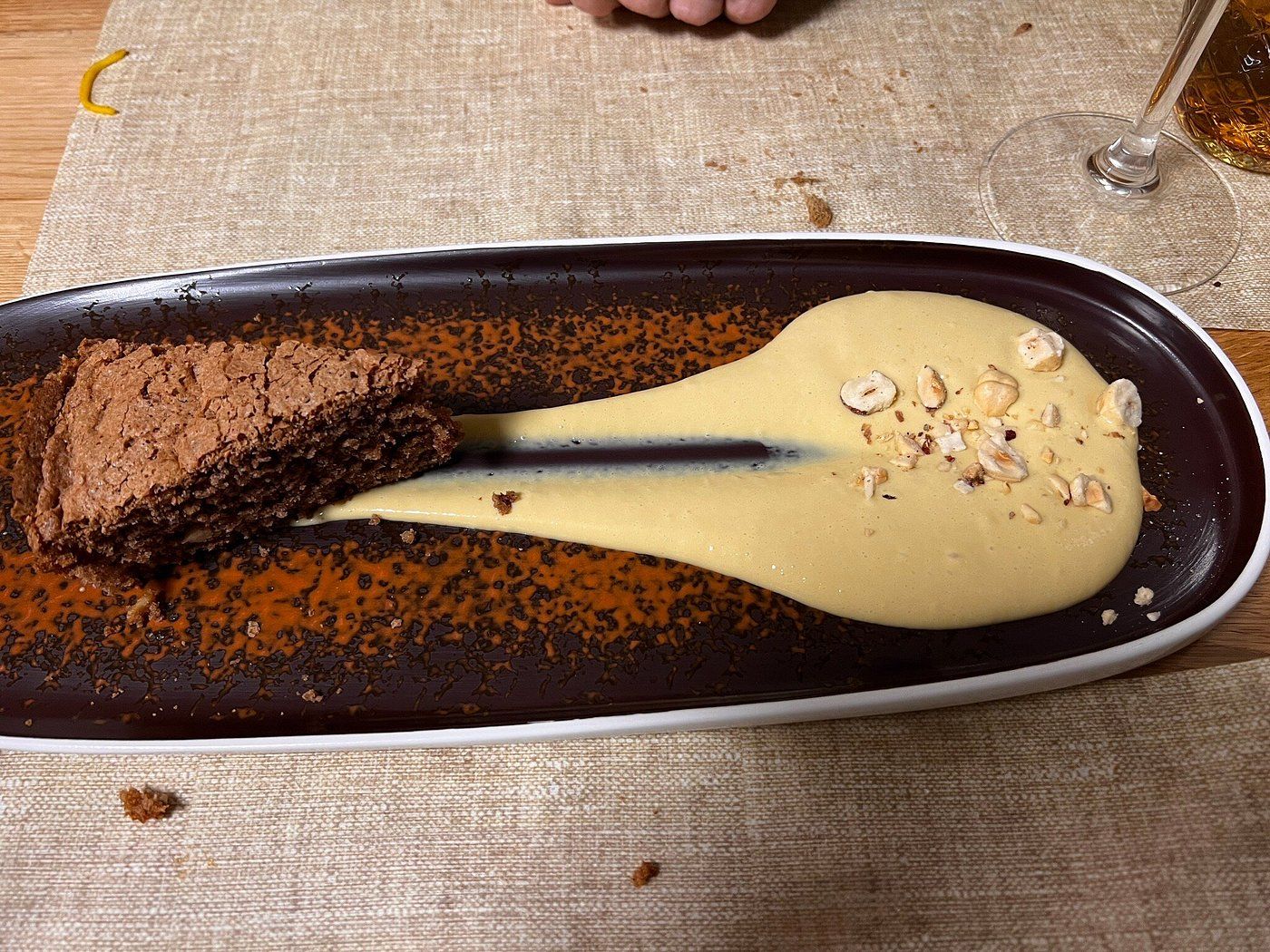 Fetta di torta di nocciole con una lunga striscia di crema allo zabaione